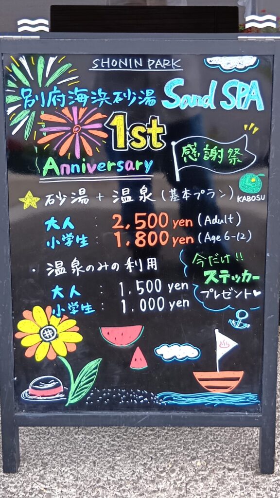 SHONIN PARK1周年記念のイベントを黒板に書いているSand spa。金額だけでなく、ひまわりやスイカ花火、ヨットにかぼすといった、夏らしい楽しいイラストが添えられている。