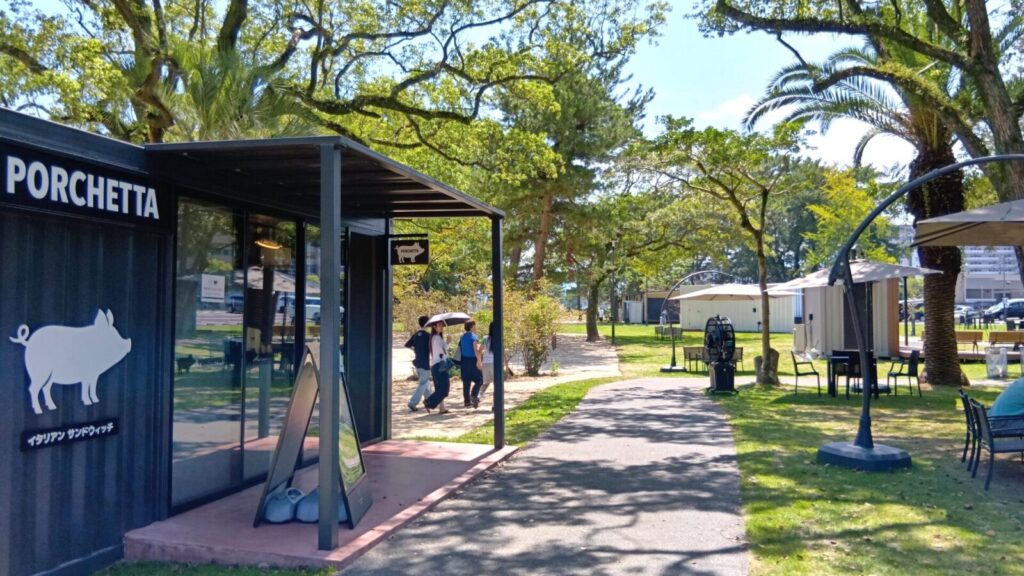 別府のSHONIN PARK（上人ヶ浜公園）のショップ周辺は、海外リゾート地の様な景色。木漏れ日の中散策が楽しい。